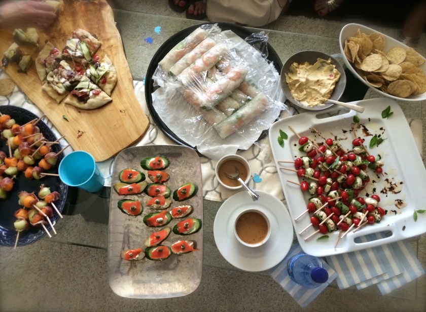 Melon balls with prosciutto, Vietnamese summer rolls, roasted potatoes and cucumbers with creme fraiche and capers, tomato caprese skewers
