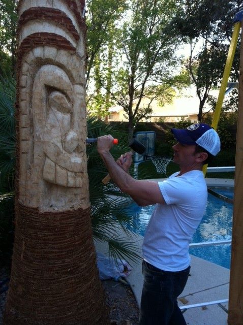 Adam carving a Tiki god into a large palm tree. Photo courtesy of Adam Throgmorton